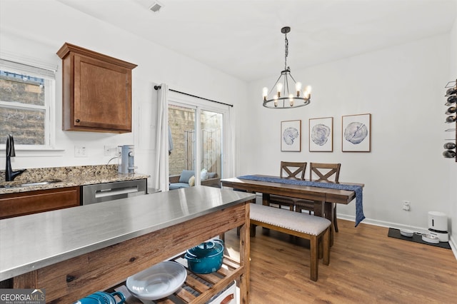 dining room featuring baseboards, an inviting chandelier, and wood finished floors