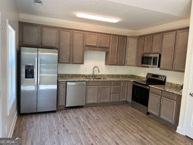 202 Gamel Rd, Dallas, GA 30157 - kitchen with dark stone countertops, light wood-type flooring, a sink, and appliances with stainless steel finishes