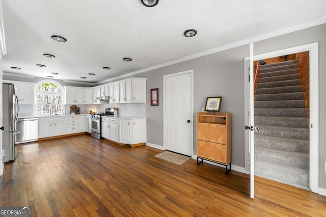 kitchen featuring dark wood-style floors, light countertops, white cabinetry, crown molding, and appliances with stainless steel finishes