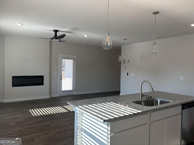 kitchen featuring open floor plan, dishwasher, and a sink
