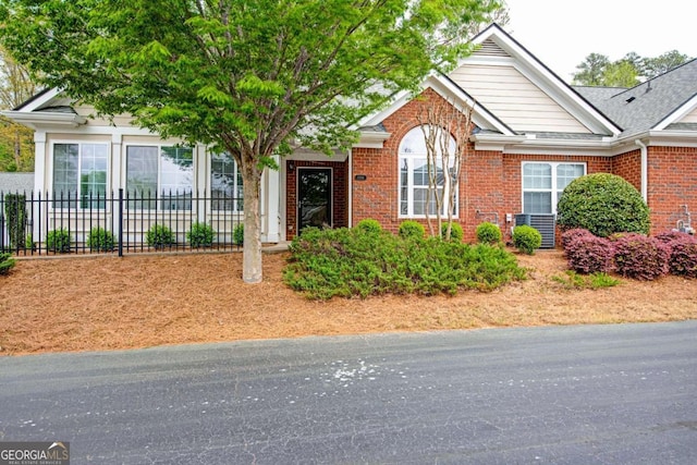 ranch-style house featuring brick siding and fence