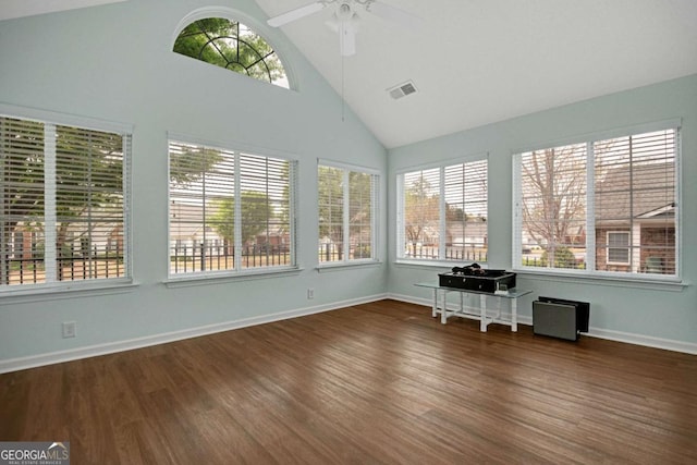 unfurnished sunroom featuring high vaulted ceiling, visible vents, baseboards, and wood finished floors