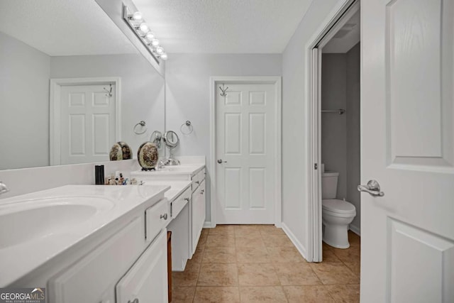 full bathroom with a sink, toilet, a textured ceiling, double vanity, and tile patterned flooring
