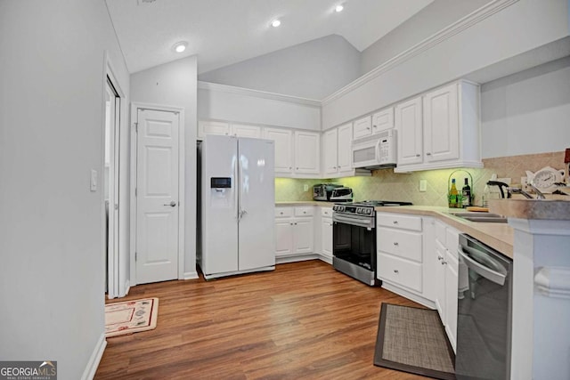kitchen with stainless steel appliances, light wood finished floors, white cabinets, and vaulted ceiling
