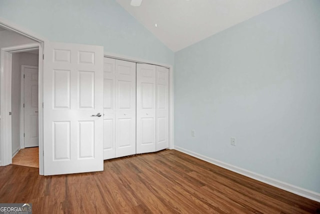 unfurnished bedroom with a closet, baseboards, ceiling fan, wood finished floors, and lofted ceiling