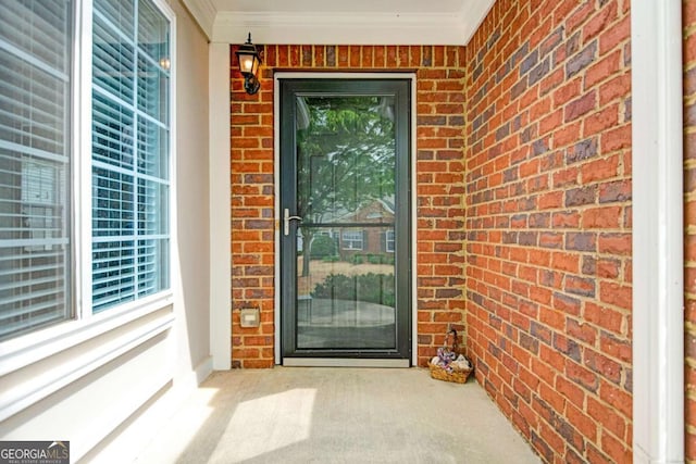 entrance to property featuring brick siding