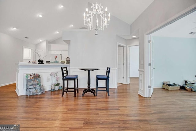dining space featuring an inviting chandelier, recessed lighting, vaulted ceiling, and wood finished floors