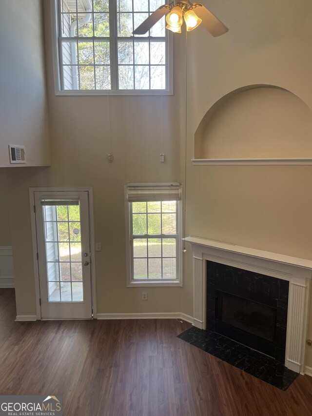 2127 Manhattan Pkwy, Decatur, GA 30035 - unfurnished living room featuring ceiling fan, a fireplace, a wealth of natural light, wood finished floors, and visible vents