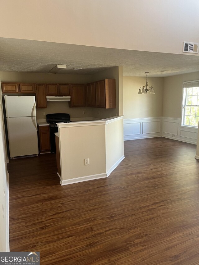 2127 Manhattan Pkwy, Decatur, GA 30035 - kitchen with visible vents, freestanding refrigerator, an inviting chandelier, black range with gas stovetop, and dark wood finished floors