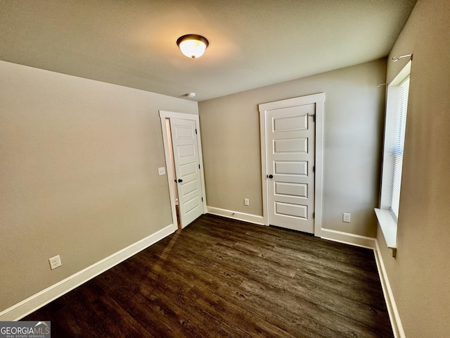 1037 E Doyle St, Toccoa, GA 30577 - unfurnished bedroom featuring dark wood-type flooring and baseboards