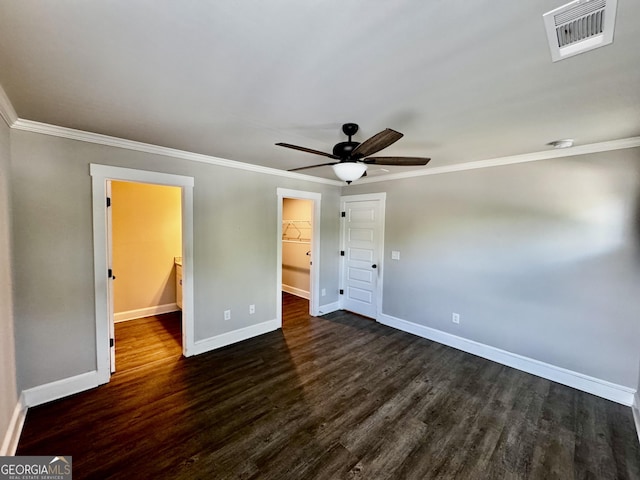 1037 E Doyle St, Toccoa, GA 30577 - unfurnished bedroom featuring a walk in closet, dark wood-style flooring, ornamental molding, a closet, and ceiling fan
