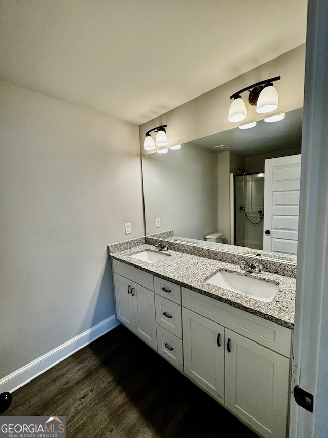 1037 E Doyle St, Toccoa, GA 30577 - full bathroom with wood finished floors, double vanity, and a shower with shower door