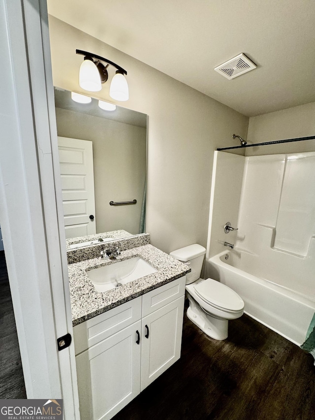 1037 E Doyle St, Toccoa, GA 30577 - bathroom with wood finished floors, vanity, and washtub / shower combination