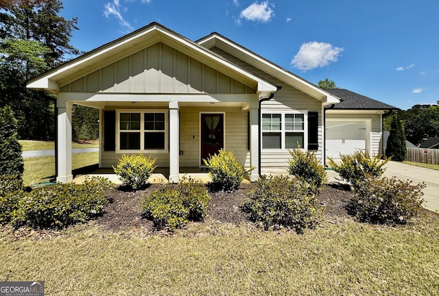 1037 E Doyle St, Toccoa, GA 30577 - view of front of property featuring an attached garage, board and batten siding, a porch, concrete driveway, and a front lawn