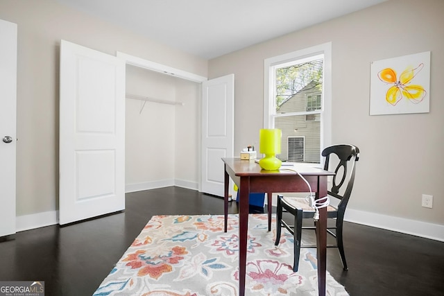 dining space featuring baseboards and dark wood-style floors