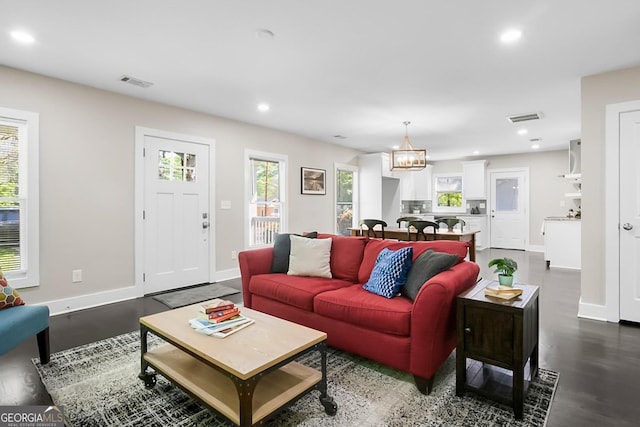 living area featuring dark wood-style flooring, baseboards, and visible vents