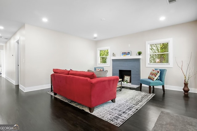 living room featuring visible vents, recessed lighting, wood finished floors, a brick fireplace, and baseboards