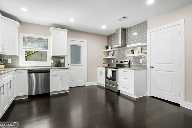 kitchen featuring visible vents, open shelves, wall chimney exhaust hood, stainless steel appliances, and decorative backsplash