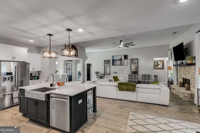 kitchen featuring open floor plan, appliances with stainless steel finishes, a sink, and recessed lighting