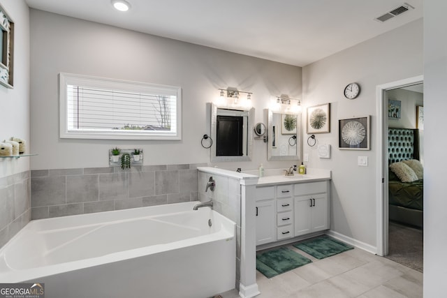 ensuite bathroom with tile patterned floors, visible vents, vanity, a bath, and ensuite bathroom