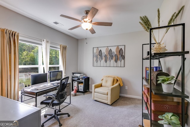 carpeted office space featuring ceiling fan, baseboards, and visible vents
