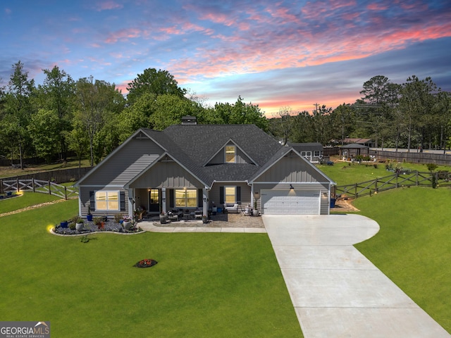 craftsman-style home featuring a chimney, driveway, board and batten siding, fence, and a yard