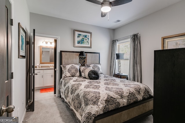bedroom with light colored carpet, ceiling fan, connected bathroom, and visible vents