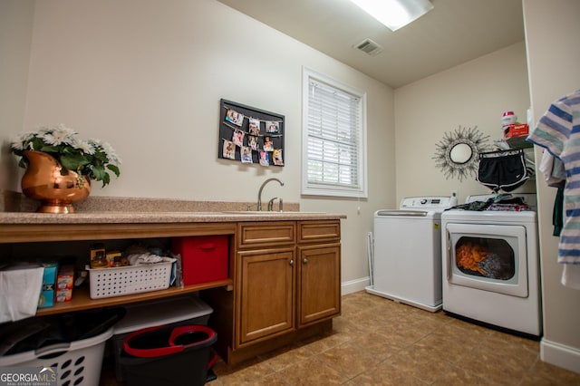 4149 Yancey Rd, Douglasville, GA 30135 - laundry area featuring visible vents, baseboards, washer and dryer, a sink, and cabinet space