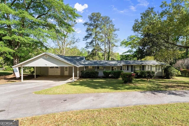 ranch-style house with a carport, aphalt driveway, and a front yard