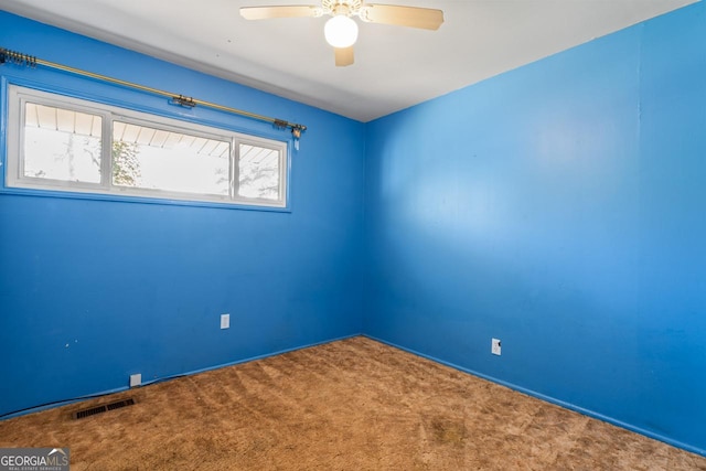 spare room with a ceiling fan, visible vents, and carpet floors