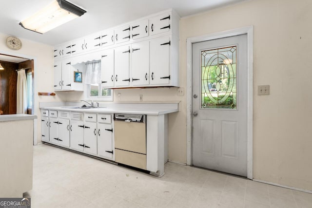 kitchen featuring white cabinets, dishwasher, light countertops, and a sink