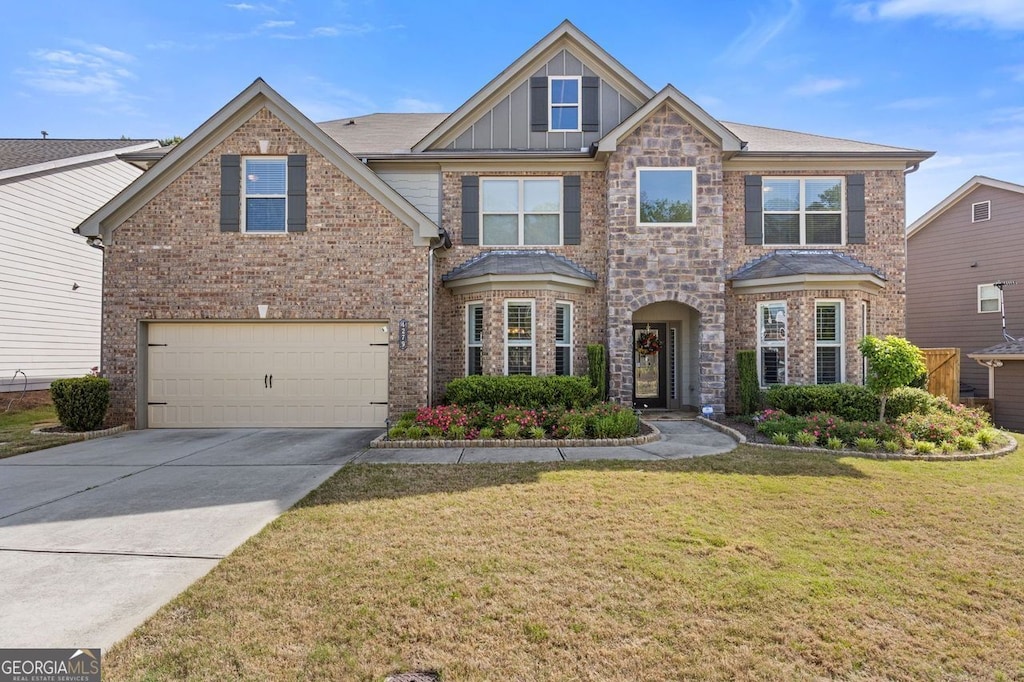 4279 Two Bridge Dr, Buford, GA 30518 - view of front of property featuring brick siding, an attached garage, driveway, a front yard, and board and batten siding