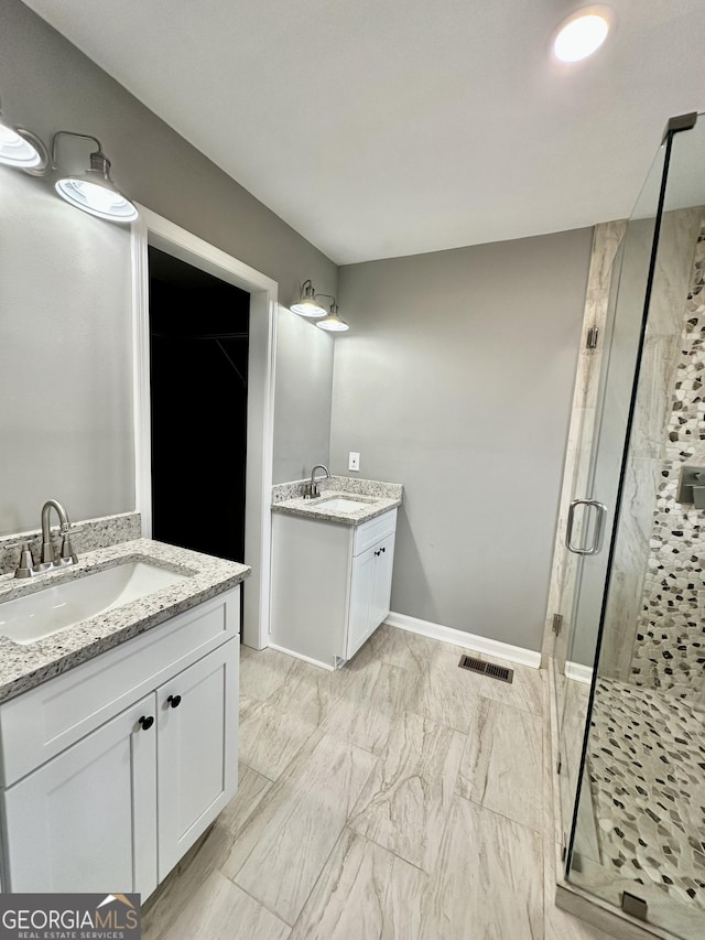 bathroom with a sink, visible vents, two vanities, and a stall shower