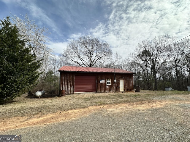 view of outbuilding featuring driveway and an outbuilding