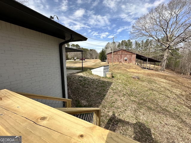 view of yard featuring a carport and an outbuilding