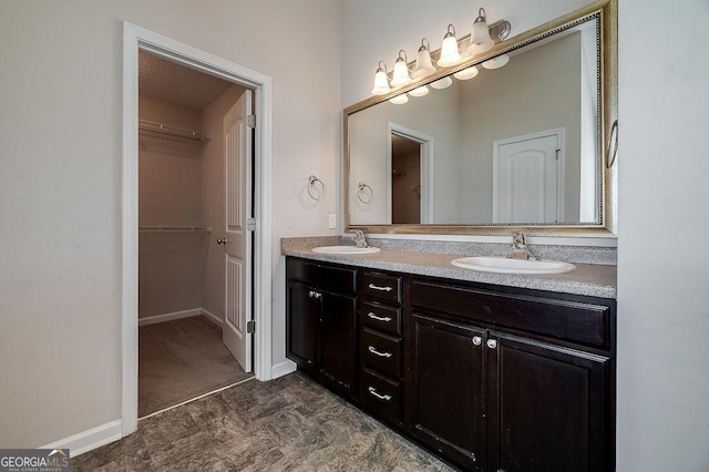 1508 Bayberry Dr, Hinesville, GA 31313 - bathroom featuring baseboards, double vanity, a sink, and a walk in closet