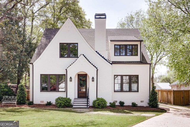 view of front of property featuring crawl space, fence, a chimney, and a front lawn