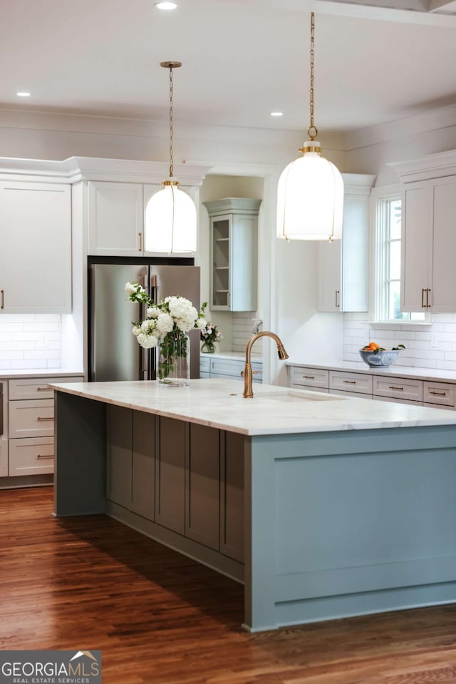 kitchen with dark wood-style flooring, freestanding refrigerator, and decorative backsplash