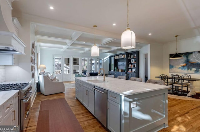 kitchen featuring a sink, stainless steel appliances, open floor plan, gray cabinetry, and coffered ceiling