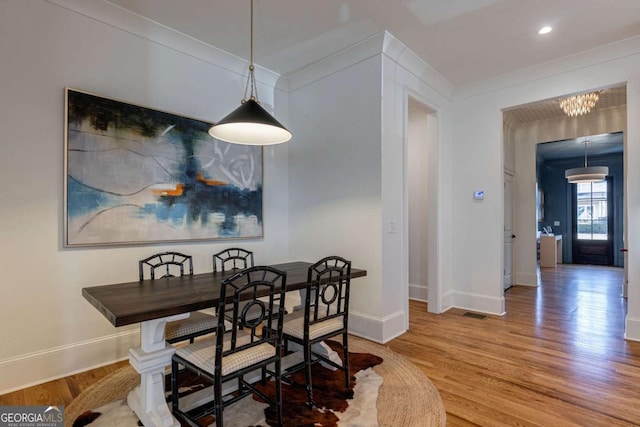 dining room featuring baseboards, a notable chandelier, ornamental molding, recessed lighting, and wood finished floors