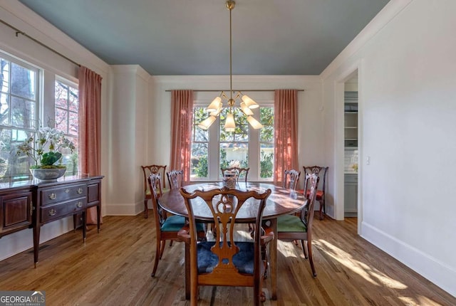 dining room featuring baseboards, an inviting chandelier, and wood finished floors