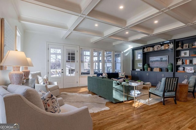 living area featuring beam ceiling, a wealth of natural light, coffered ceiling, and wood finished floors
