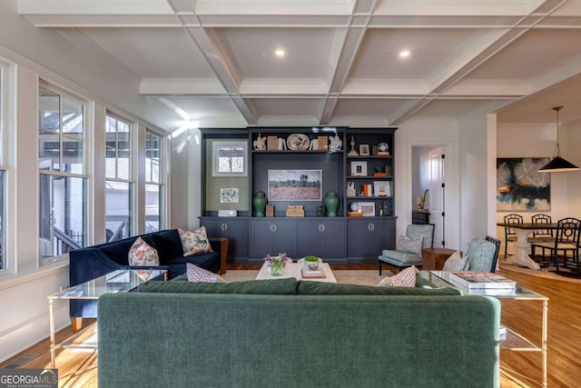living area with crown molding, beamed ceiling, and wood finished floors