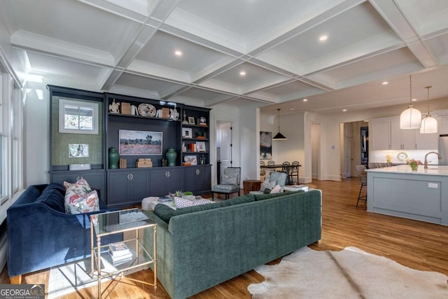 living area featuring light wood-type flooring, baseboards, recessed lighting, beam ceiling, and coffered ceiling