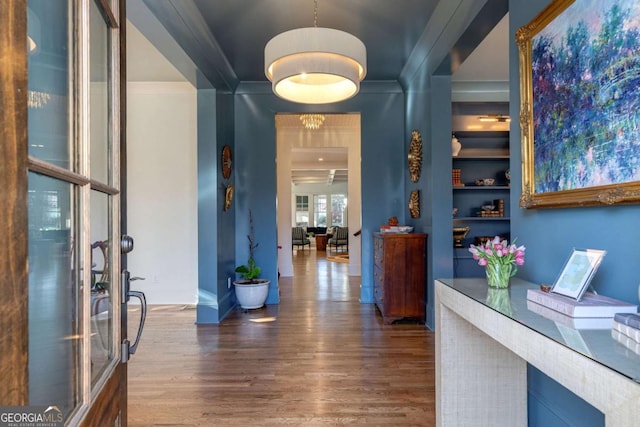hallway with crown molding and wood finished floors
