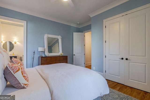 bedroom featuring a closet, ensuite bathroom, crown molding, ceiling fan, and wood finished floors