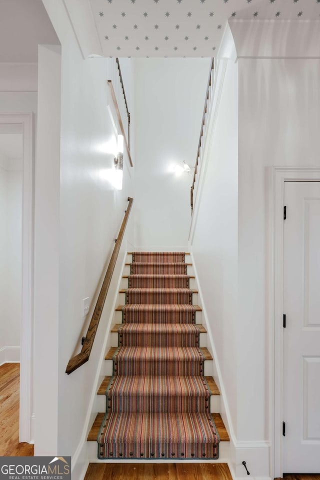 stairway featuring baseboards and wood finished floors