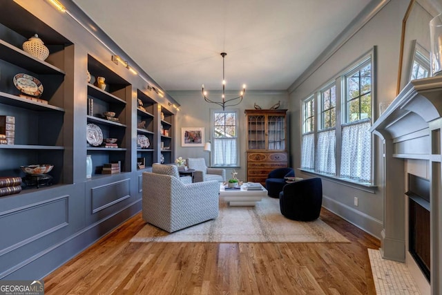 sitting room with a healthy amount of sunlight, wood finished floors, and a notable chandelier