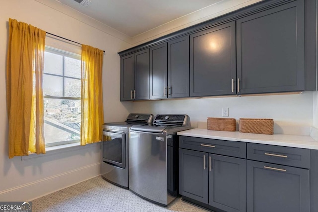 clothes washing area featuring baseboards, washer and dryer, ornamental molding, cabinet space, and light floors