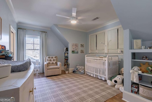 bedroom featuring light wood finished floors, visible vents, and a ceiling fan
